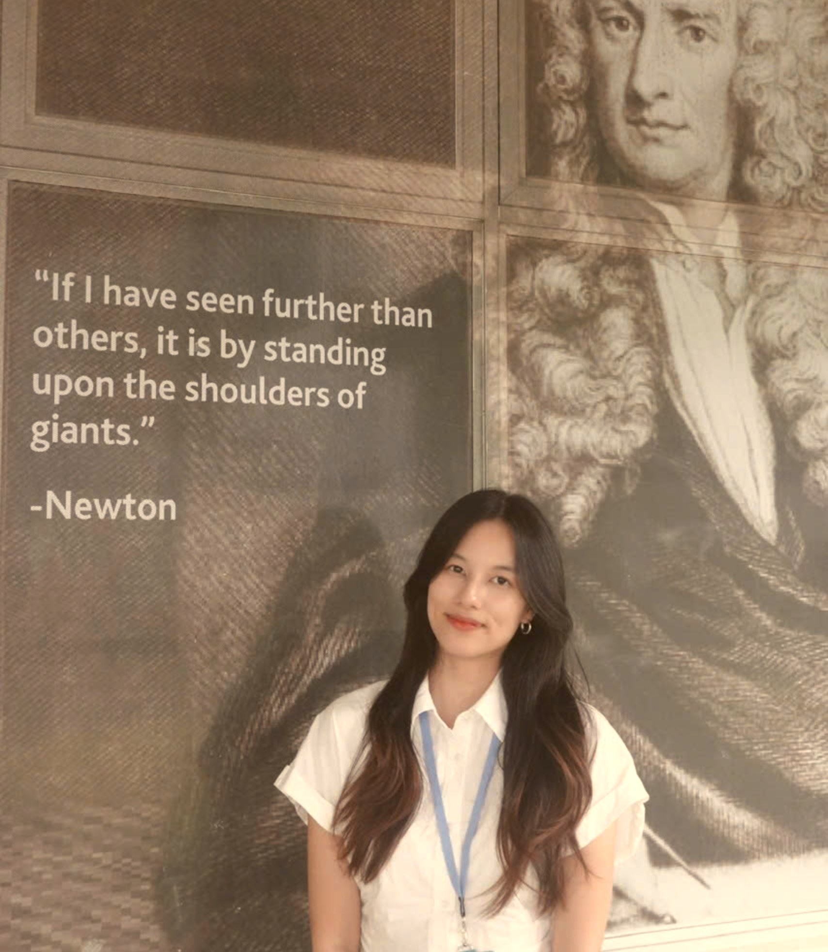 Le Khanh Linh in front of an Isaac Newton portrait reading 'If I have seen further than others, it is by standing upon the shoulders of giants.'